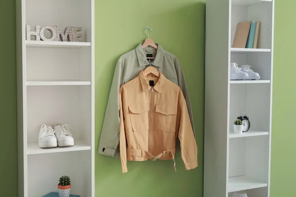 Shelving Units Stylish Jackets Hanging Green Wall — Stock Photo, Image