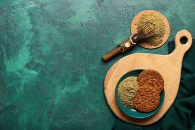 Yeşil arka planda lezzetli hojicha kurabiyeli ahşap tahta.