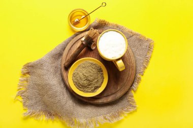 Hojicha tozuyla kase, bal, bir fincan çay ve sarı arka planda chasen.