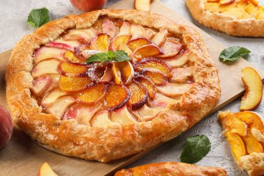 Açık arkaplanda lezzetli şeftali galeti olan tahta, yakın plan.