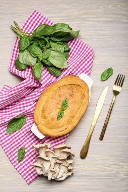 Gri ahşap arka planda lezzetli mantarlı turta pişirme