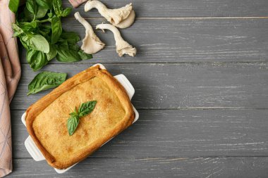 Gri ahşap arka planda lezzetli mantarlı turta pişirme