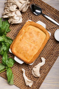 Lezzetli mantarlı kek ve gri ahşap arka planda malzemeler.