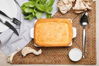 Lezzetli mantarlı kek ve gri ahşap arka planda malzemeler.