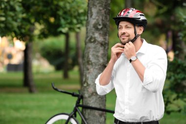 Bisiklet kasklı bir adam parkta