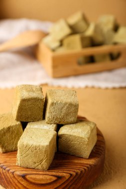 Renkli arka planda lezzetli hojicha şekerlemeleri olan tahta, yakın plan