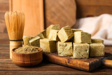 Lezzetli hojicha marşmelovları olan tahta arka planda pudra ve chasen, yakın plan.