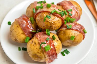 Hafif arka planda pastırmalı lezzetli fırında patates tabağı, yakın plan.