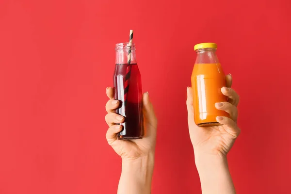Kvinnliga Händer Med Flaskor Hälsosam Juice Färg Bakgrund — Stockfoto