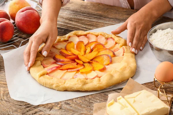 Frau Bereitet Schmackhafte Pfirsichgalette Tisch — Stockfoto