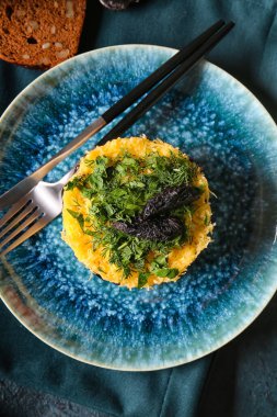 Lezzetli katmanlı salata, kuru erik ve çatal bıçaklı şık tabak, yakın çekim.