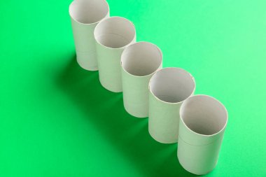 Yeşil arkaplanda boş karton tüpler çizgisi