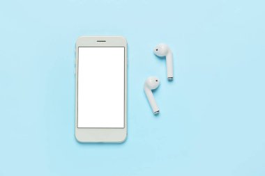 Renkli arka planda cep telefonu ve kulaklık