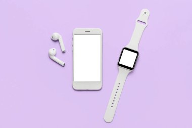 Renkli arka planda modern cep telefonu, kulaklık ve akıllı saat