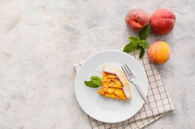 Açık arkaplanda bir parça şeftali galeti olan bir tabak.