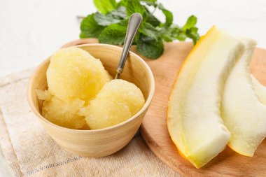 Lezzetli şerbetli kase, kavun parçaları ve hafif arkaplanda nane şekeri.