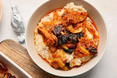 Lezzetli yulaf ezmesi, et suyu, sığır güveci ve kuru erik tabağı.