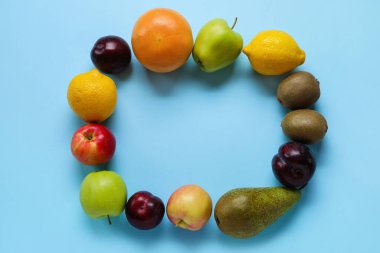 Mavi arka planda farklı meyvelerden yapılmış çerçeve. Vegan Günü