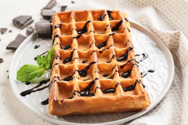 Lezzetli Belçika waffle 'ı ve çikolata soslu bir tabak.
