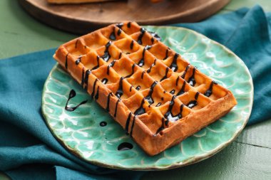 Masada çikolata soslu leziz Belçika waffle 'ı, yakın plan.