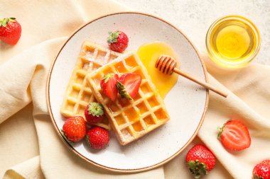 Beyaz arka planda çilekli ve ballı Belçika Waffle tabağı