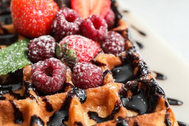 Beyaz arka planda böğürtlenli lezzetli Belçika Waffle tabağı.