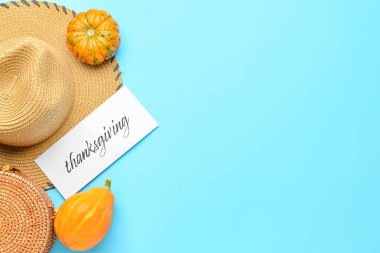 Hasır şapka, çanta, balkabağı ve kağıt kart. Renk arkaplanındaki şükranla.