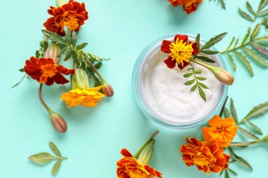 Kremalı kavanoz ve renkli çiçekli kadife çiçeği, yakın plan.