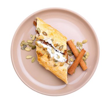 Beyaz arka planda lezzetli balkabaklı turta ve tarçın tabağı.