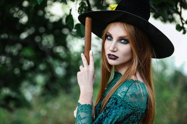 Beautiful young witch in forest