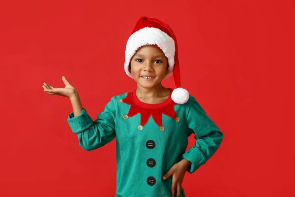 戴着圣诞帽的非洲裔美国小男孩的红色背景 — 图库照片