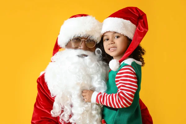Kleine Afroamerikanische Mädchen Mit Weihnachtsmann Auf Gelbem Hintergrund — Stockfoto