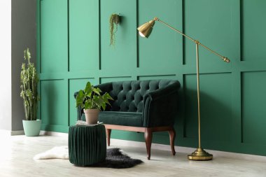 Yeşil duvarın yanında kanepesi olan modern oturma odası.