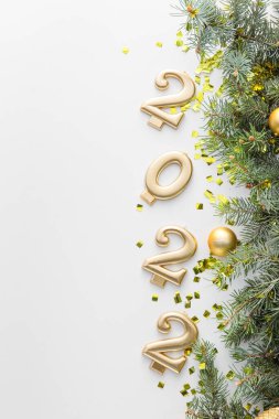 Beyaz arka planda köknar dalları ve 2022 şekli ile kompozisyon, yakın plan