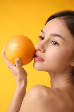 Arka planında greyfurt olan çıplak genç bir kadın. Vegan Günü