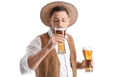 Geleneksel Alman kıyafetleri içindeki genç adam beyaz arka planda bira içiyor.