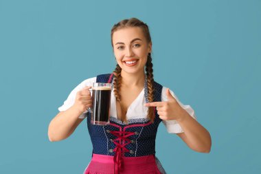 Genç Ekim Festivali garsonu mavi arka planda biraya bakıyor