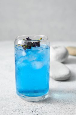 Hafif arka planda bir bardak organik mavi çay, yakın plan.