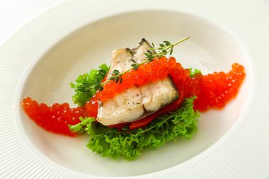 Kırmızı havyarlı lezzetli levrek balığı tabağı, yakın plan.