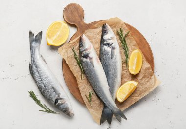 Tahta tahta tahta tahta, beyaz arka planda taze levrek balığı var.