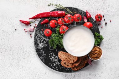 Bir kase domuz yağı, taze sebzeler ve beyaz arka planda ekmek.