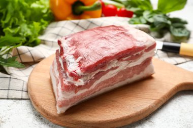 Hafif arka planda pişmemiş pastırmalı ahşap tahta.