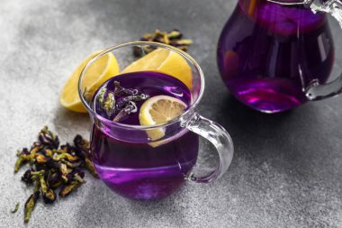 Bir fincan kelebek arkaplanda bezelye çiçeği çayı.