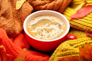 Bir fincan kahve, yaprak ve kazakla güzel bir sonbahar kompozisyonu.