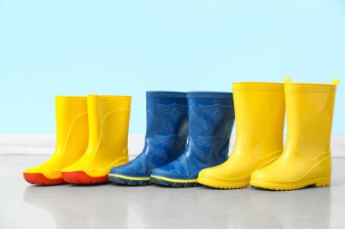 Renk duvarına karşı yerde bir sürü farklı lastik bot var.