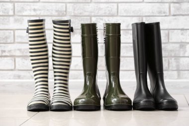 Duvarın yanında yerde farklı lastik çizmeler var.