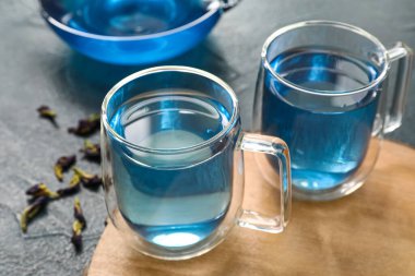 Koyu arkaplanda mavi çay fincanları, yakın plan.