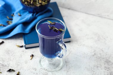 Hafif arkaplanda bir bardak mavi çay.