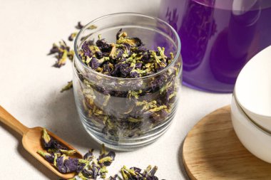 Cam kavanoz ve kurutulmuş kelebek arkaplanda bezelye çiçekleri