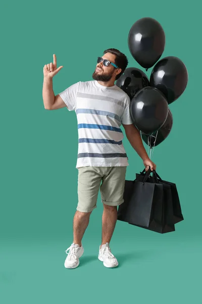 Όμορφος Άνθρωπος Μαύρη Παρασκευή Τσάντες Ψώνια Και Μπαλόνια Στο Πράσινο — Φωτογραφία Αρχείου